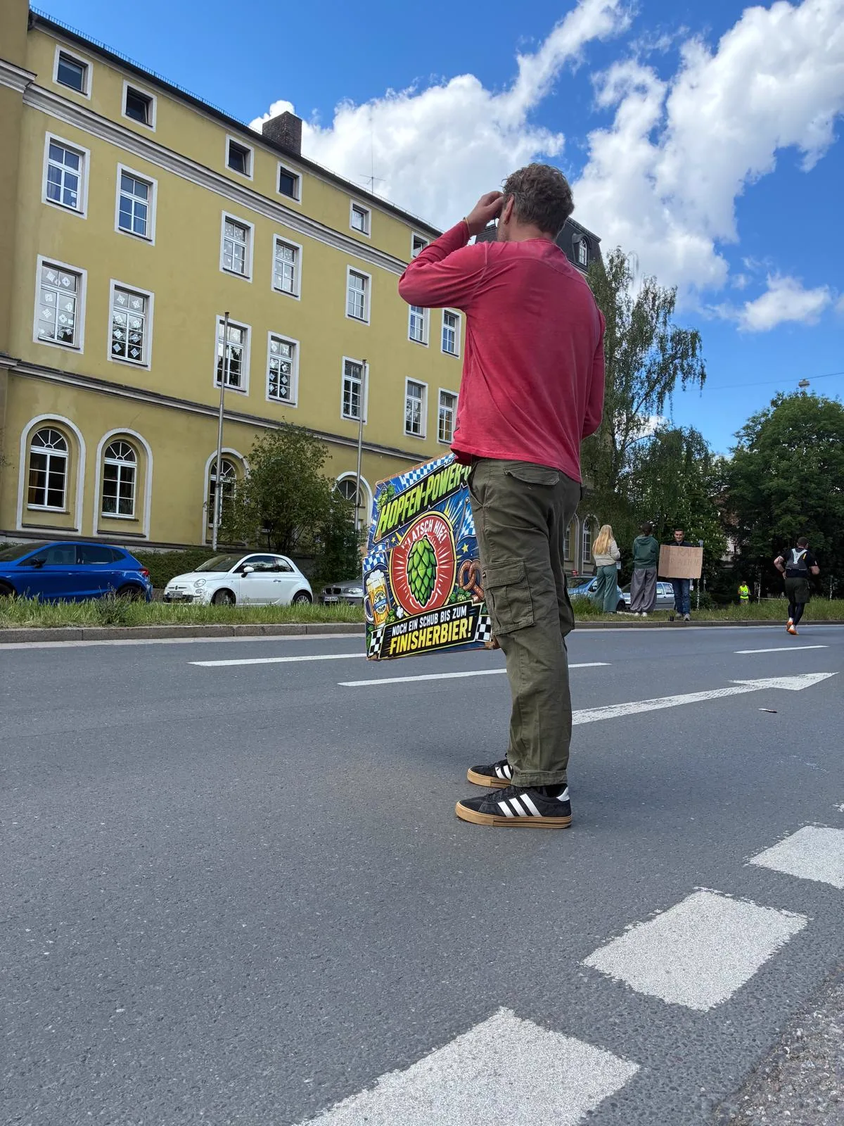 Martin von Beyond Walls mit dem Hopfen-Power-Up-Schild vor Regensburger Kulisse