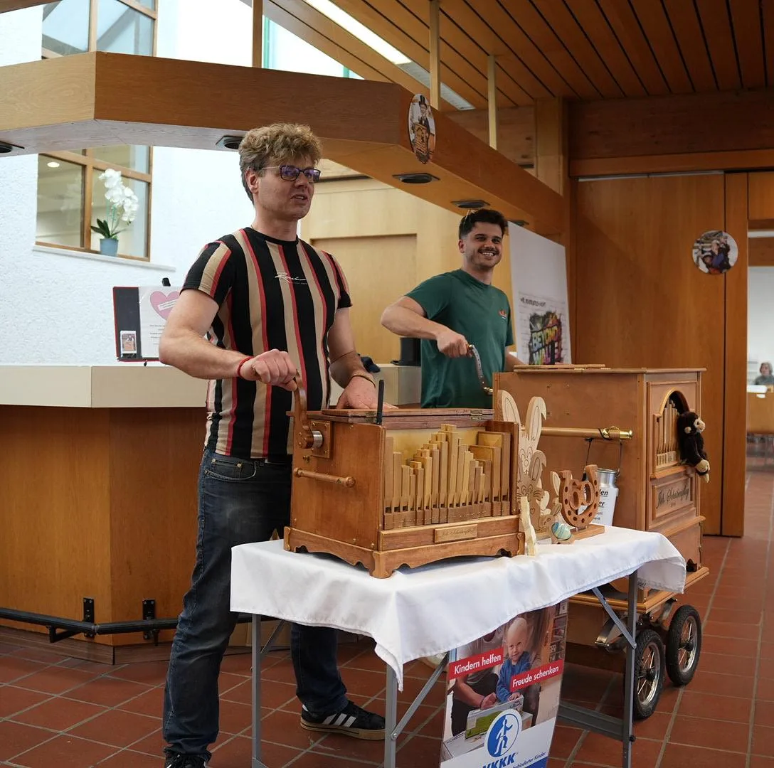 Martin und Sascha spielen kurz an der Drehorgel eines Straßenmusikers